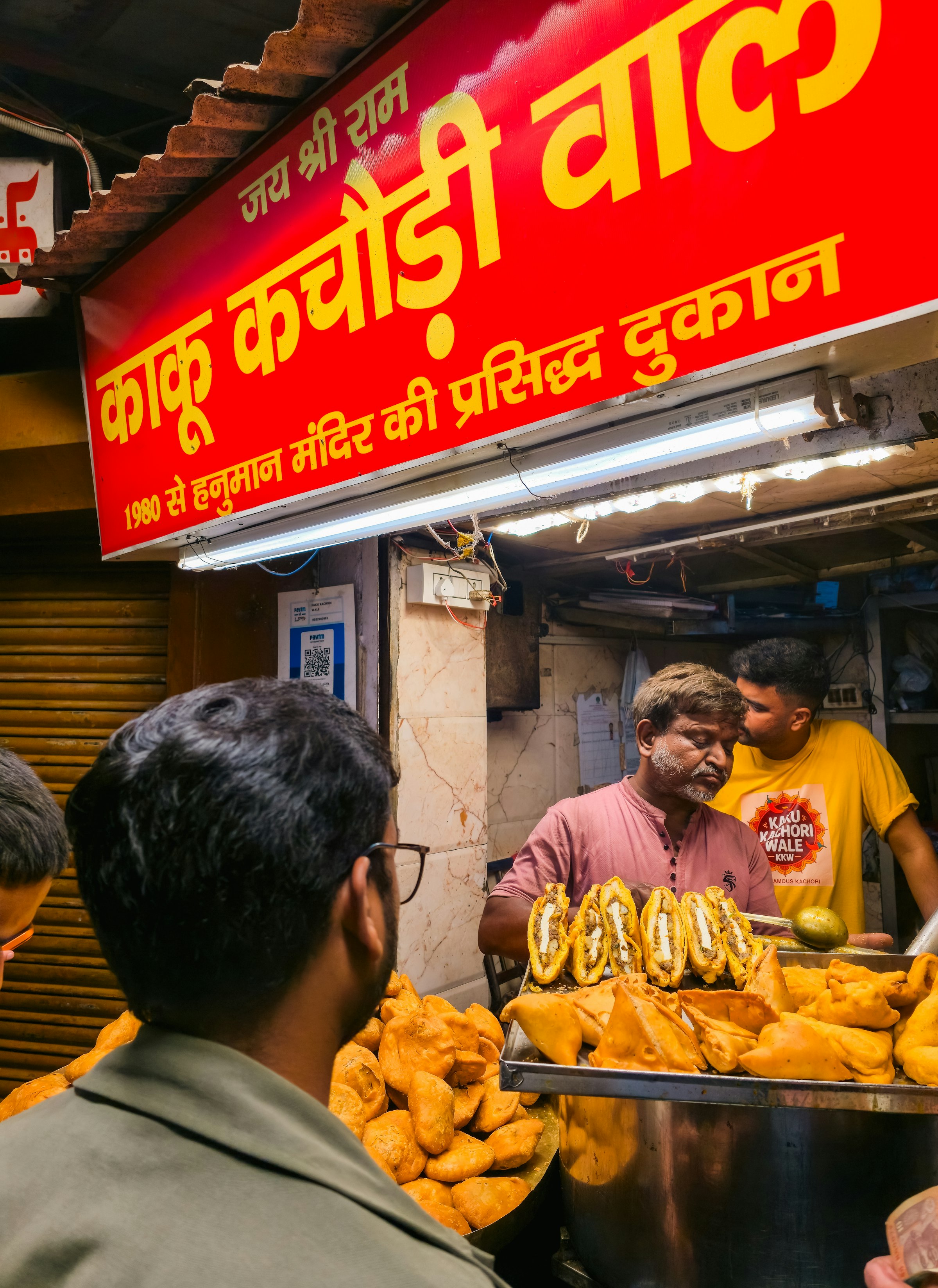 A vendor serving kachori from a metal tray