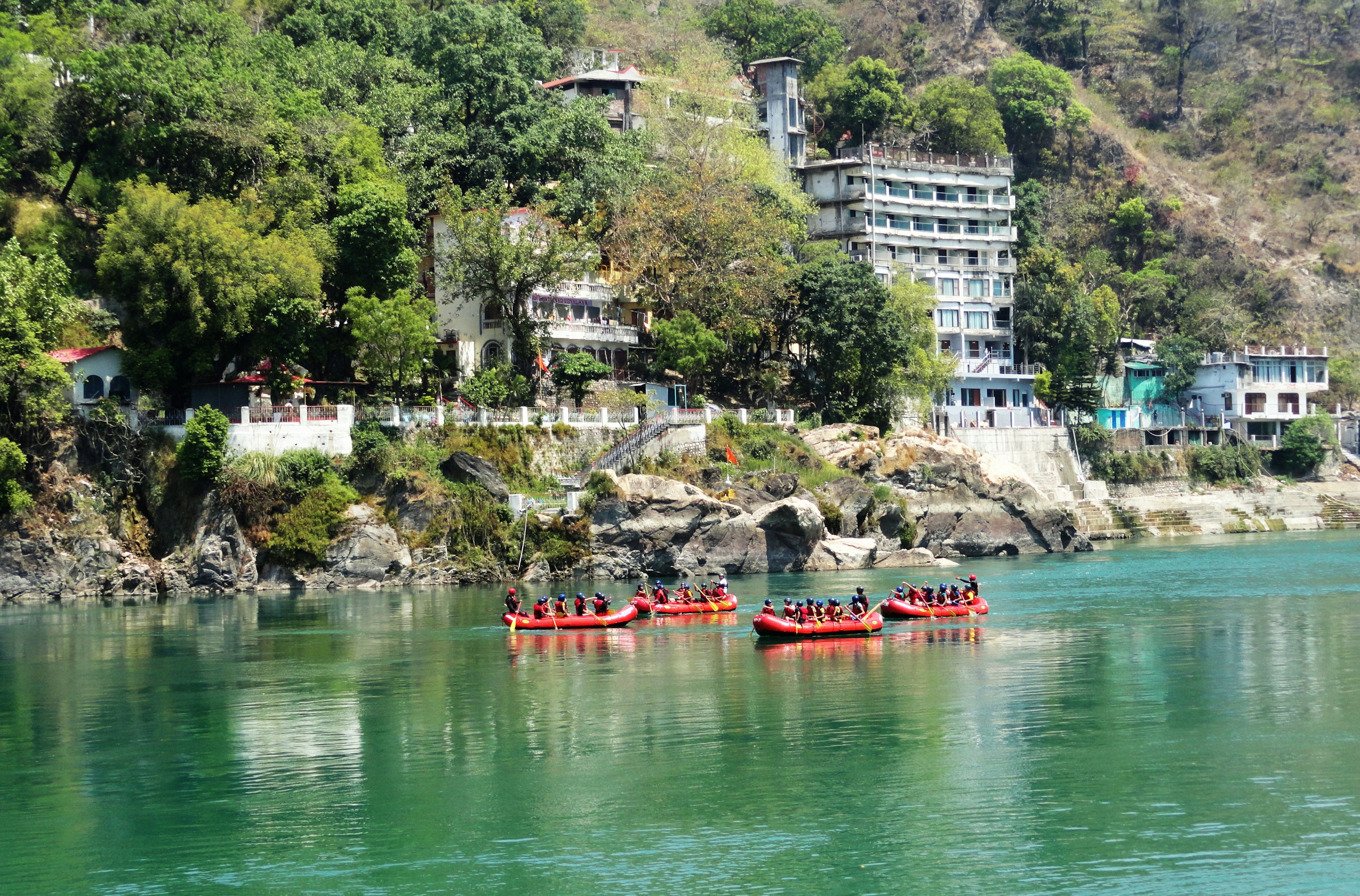 People paddling a red kayak down the river