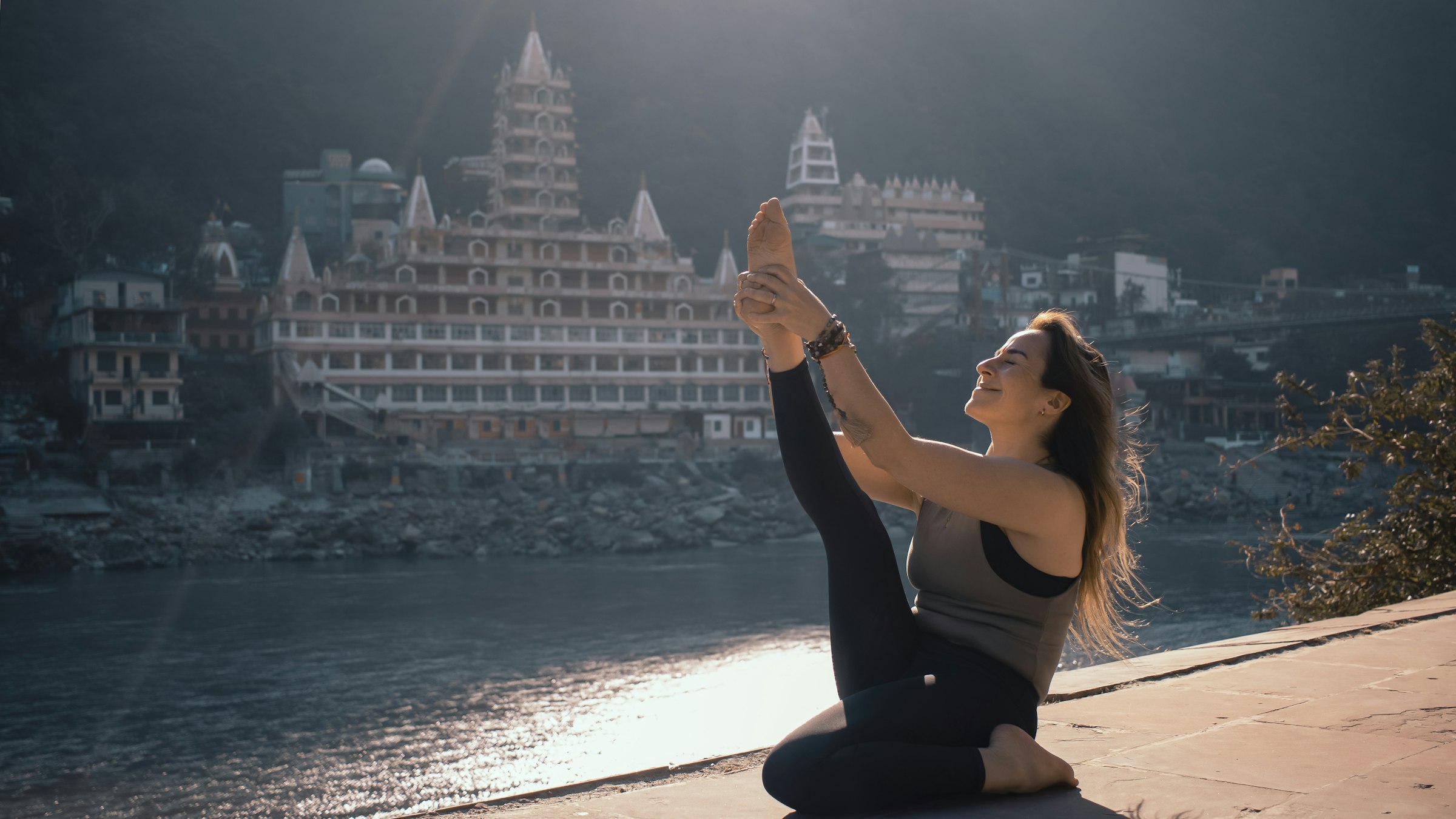 A woman practising yoga on the edge of a cliff