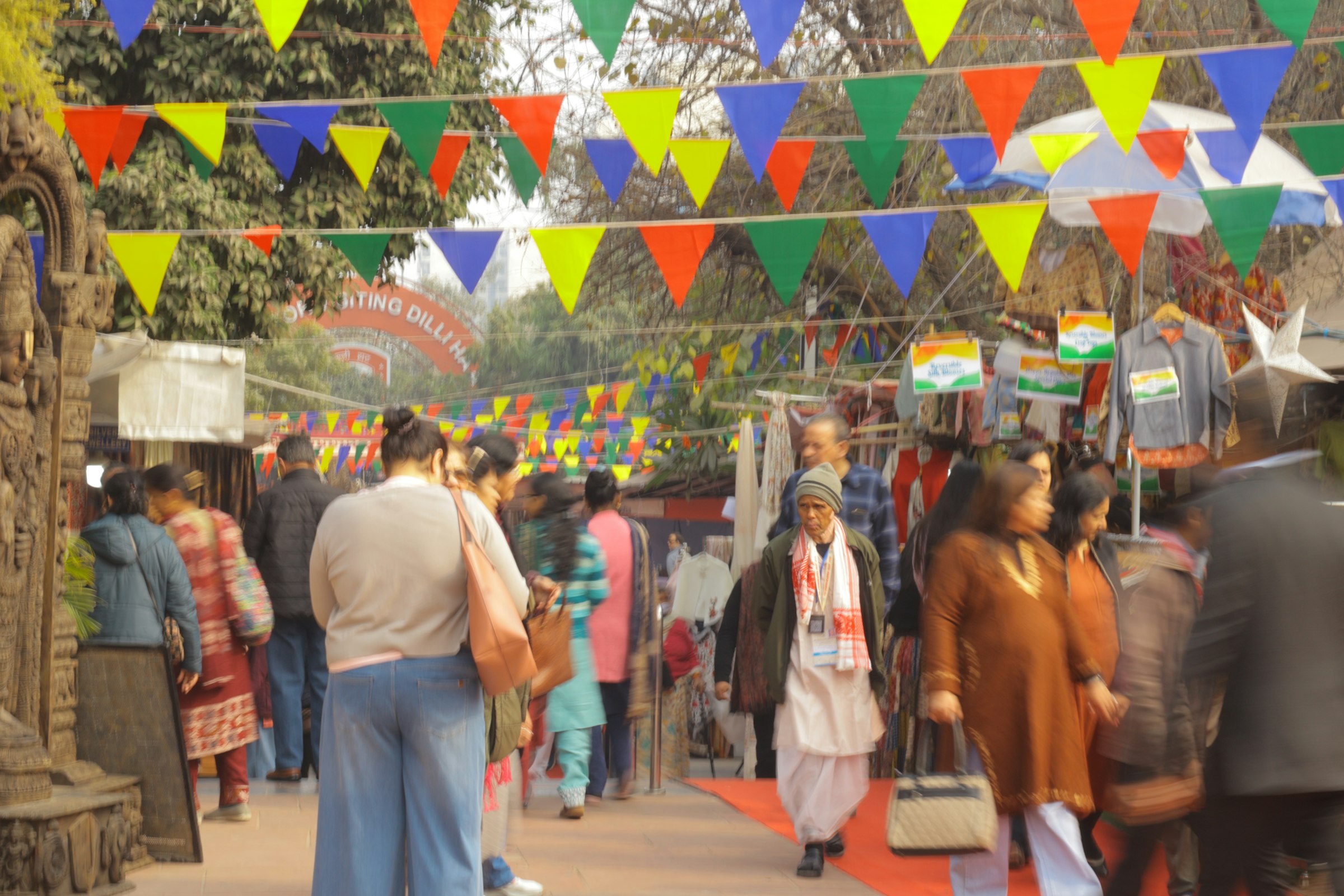 People browsing colourful stalls at Dilli Haat