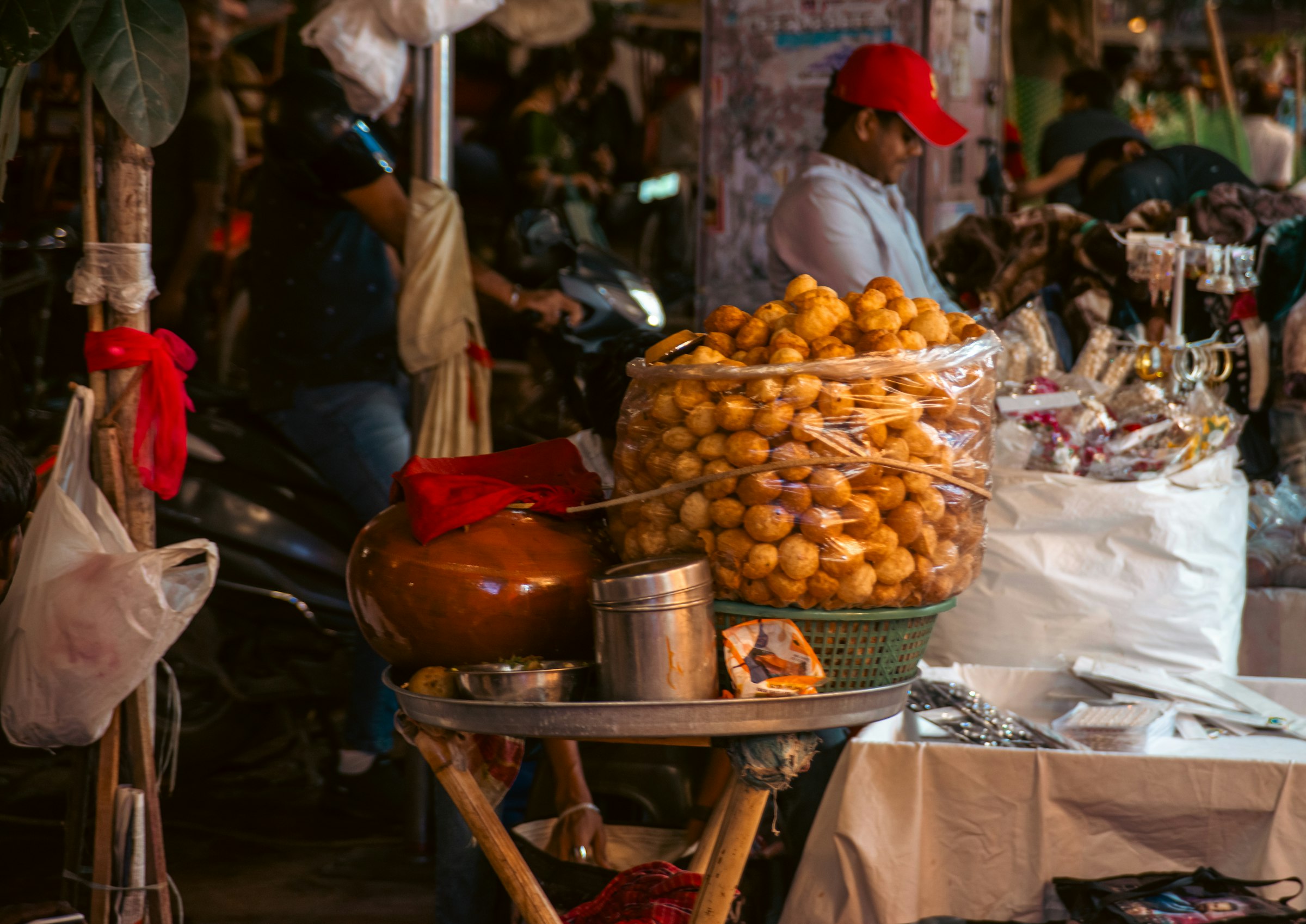 A street vendor filling golgappe from a large container