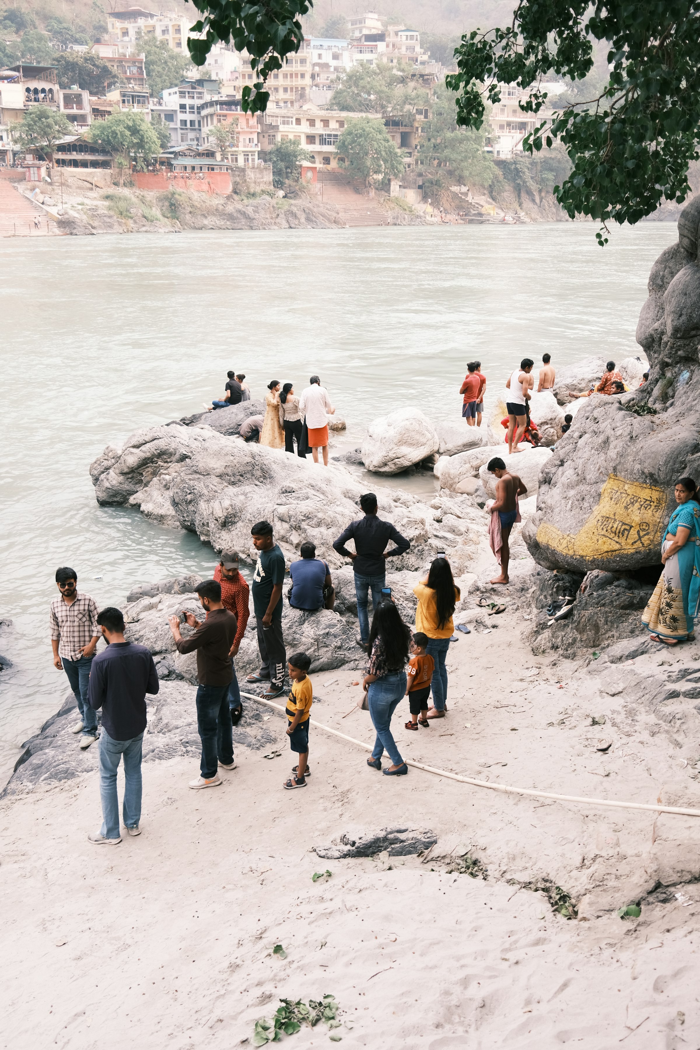 A small group on a sandy beach beside the Ganga
