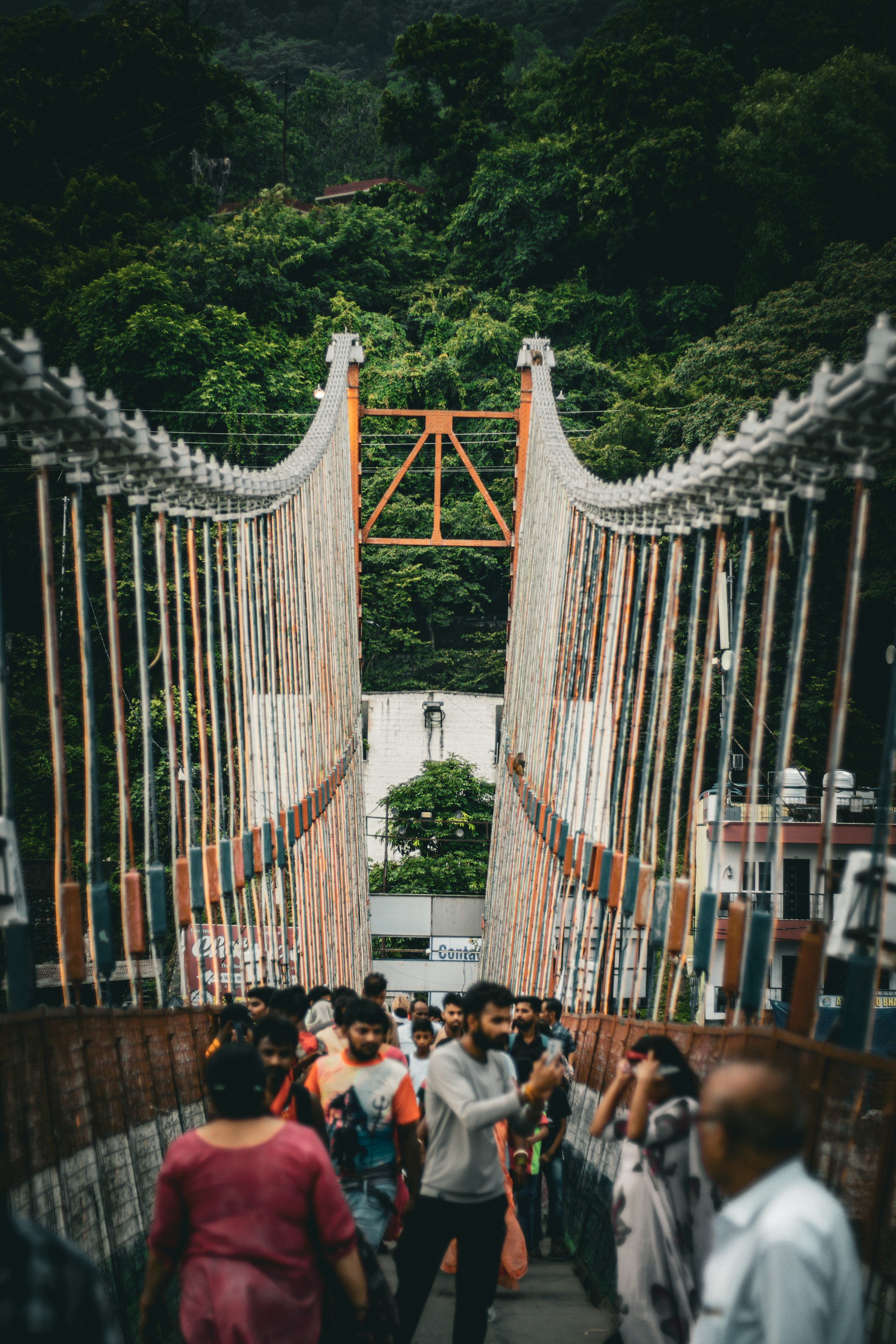 People walking across a suspension bridge over the Ganga