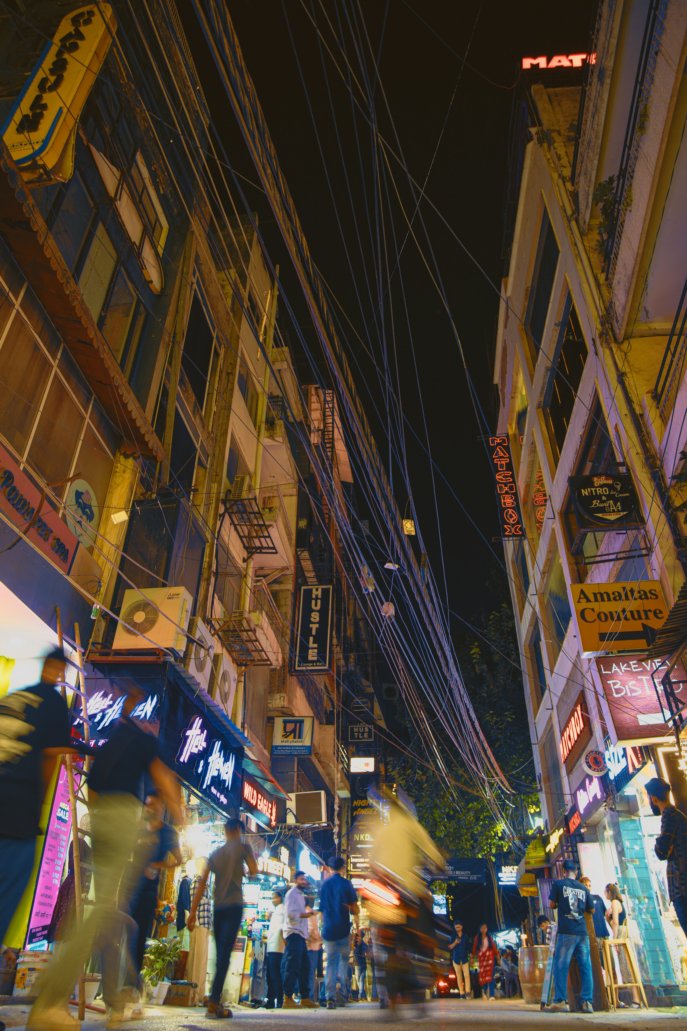 People walking down a narrow street in Hauz Khas